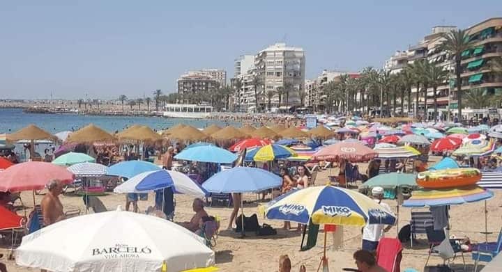 Playa de la Cura Torrevieja bustling with sunbathers.